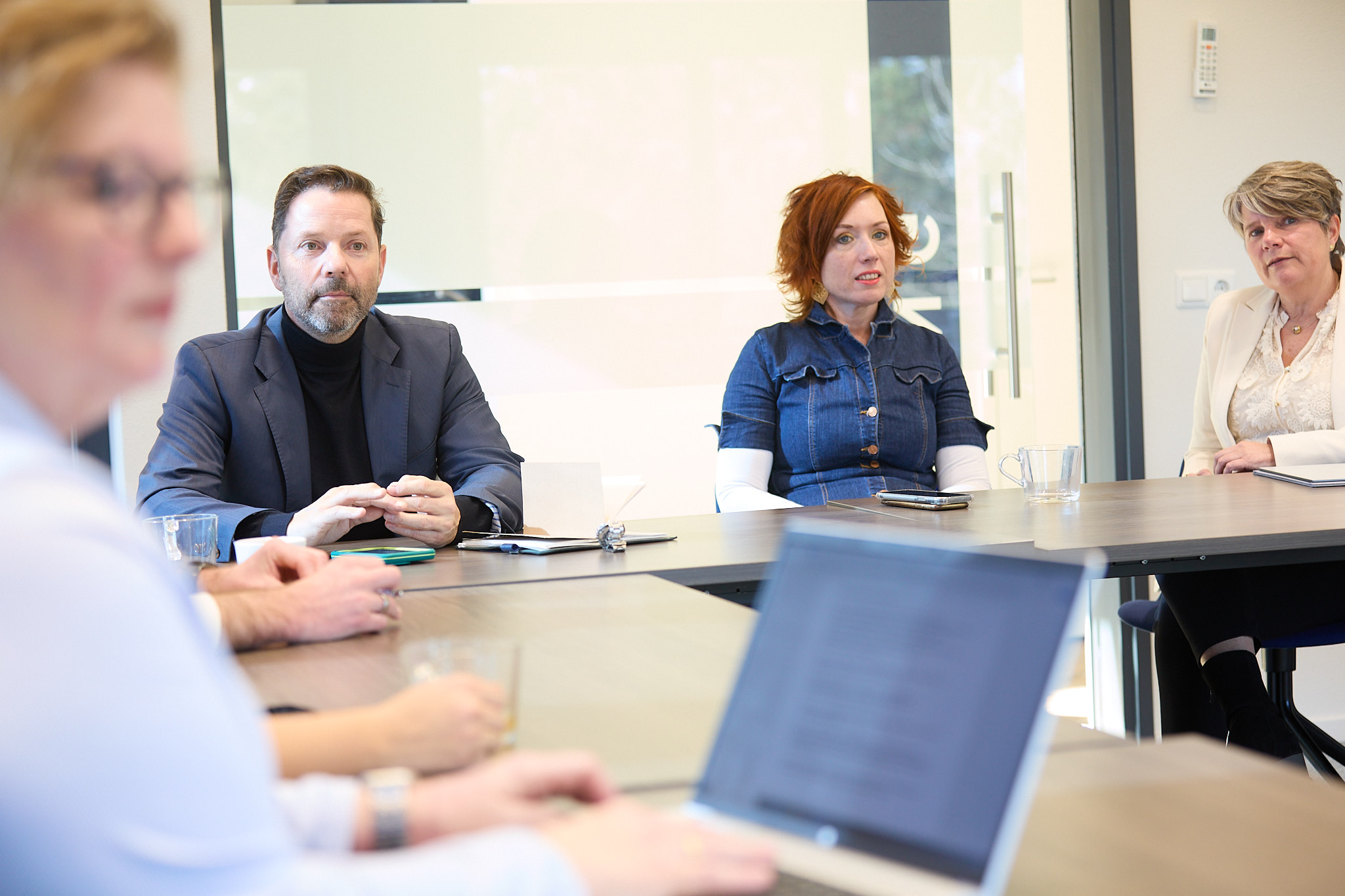 Team van Staatvandienst AD in vergaderruimte tijdens informeel overleg.